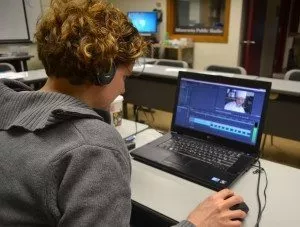 Student using computer with headphones on
