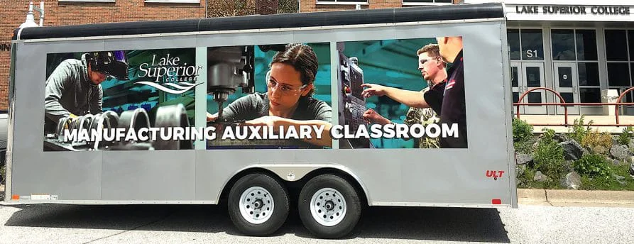 Manufacturing Auxiliary Classroom banner on side of trailer shows students working
