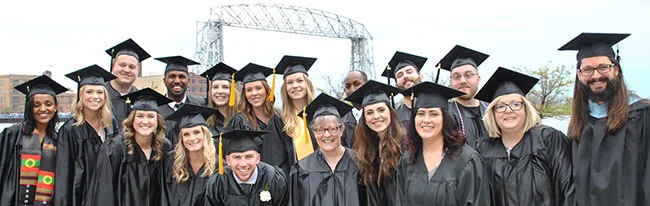 Graduates pose in front of Duluth's lift bridge