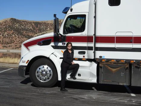 Liz Hartel, Truck Driving Program alum stands in front of truck